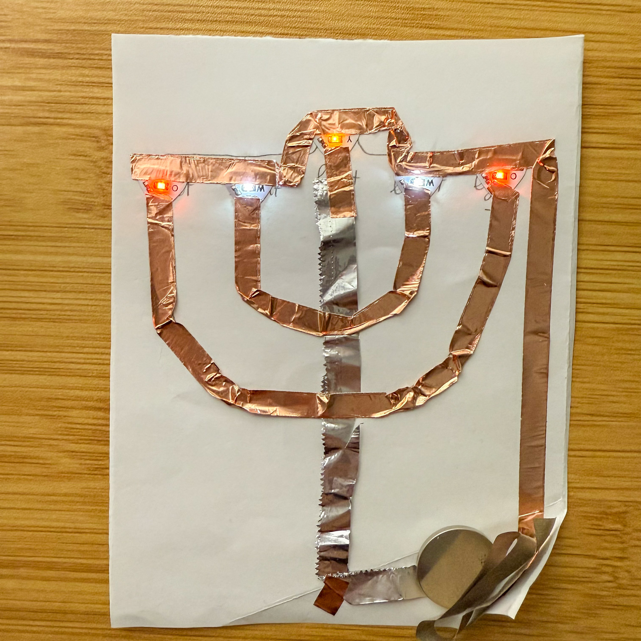 Using the conductive fabric as a button which connects the battery to the circuit and ready to test.