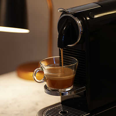 The gurgling of a Nespresso machine as it brews espresso, with the distinct sound of pressurized water flowing through coffee grounds and filling the cup.