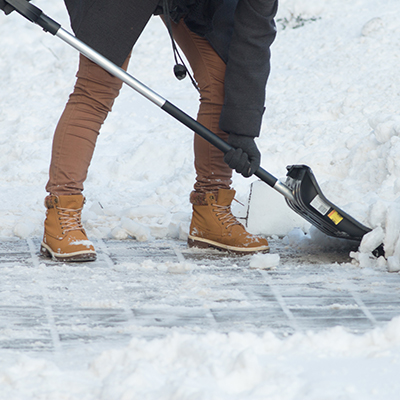 The scraping sound of a shovel clearing snow from a sidewalk.