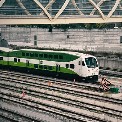 The sound is a repetitive ringing of a GO train bell, signaling arrival or departure with a distinct, steady chime that resonates across the railway platform.